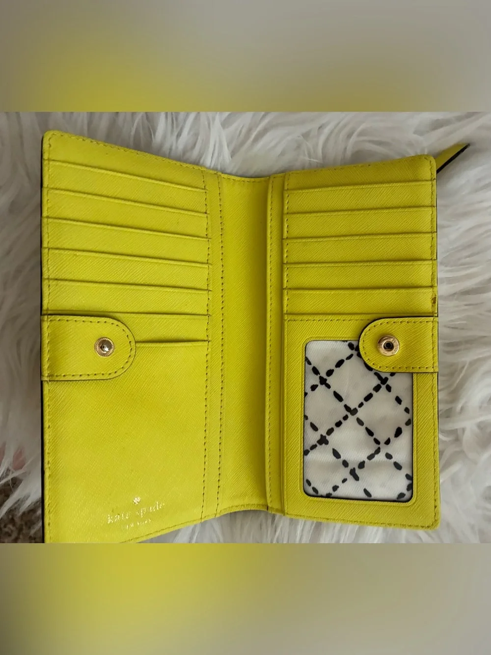Lime green Kate Spade New York slim bifold wallet features multiple card slots